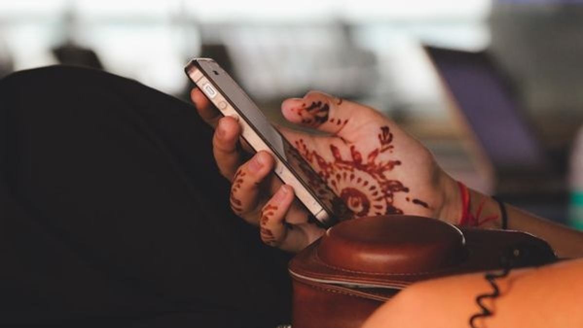 Image showcasing a wealthy Indian consumer using an iPhone