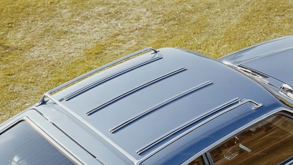 A row of fuel-efficient cars parked against a city skyline.